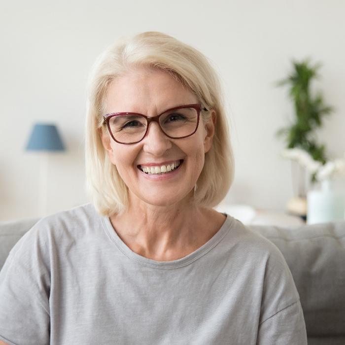 A smiling middle-aged woman using dental bridges