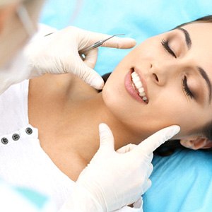 Dentist examining woman’s smile