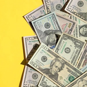 Cash spread out on yellow background