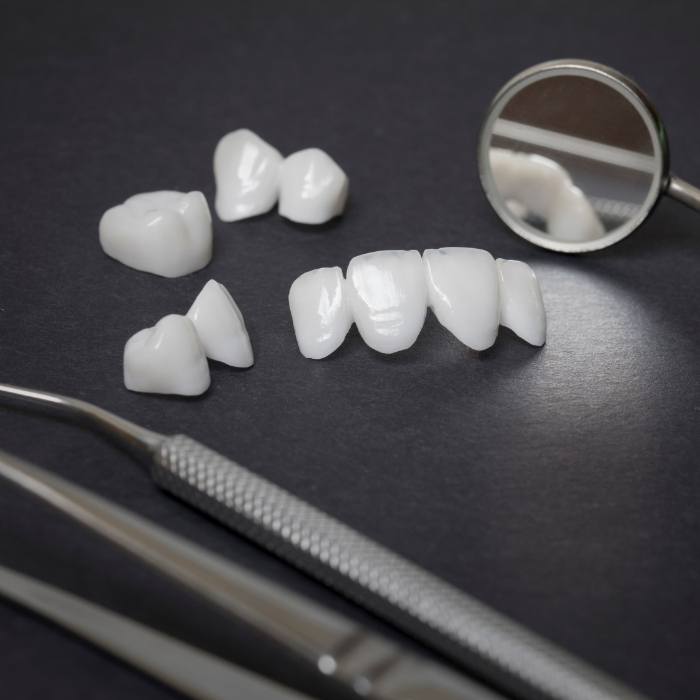Metal free dental crowns and bridges on dark gray surface