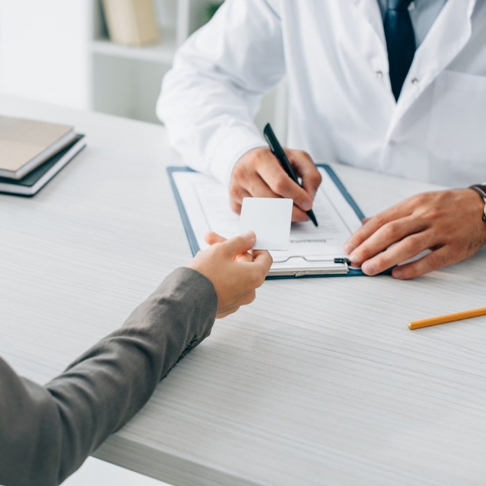 Patient handing dentist a payment card