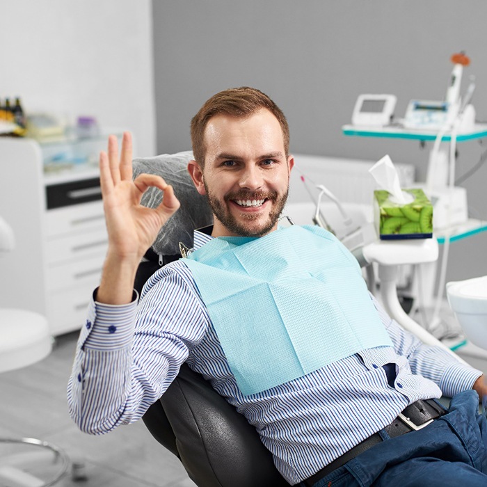 Male dental patient giving the “okay” sign
