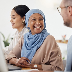 Woman smiling at colleague while working in office