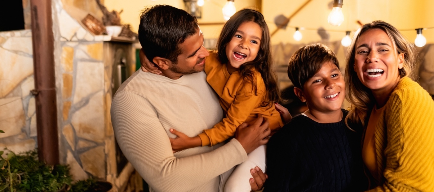 Family of four smiling in restaurant