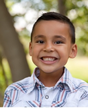 Young boy grinning outdoors