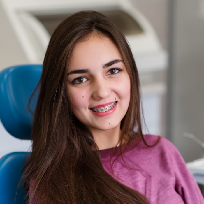 Young dental patient smiling with traditional braces