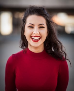 Smiling woman in red sweater with red lipstick