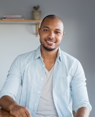 Man in light blue plaid shirt smiling