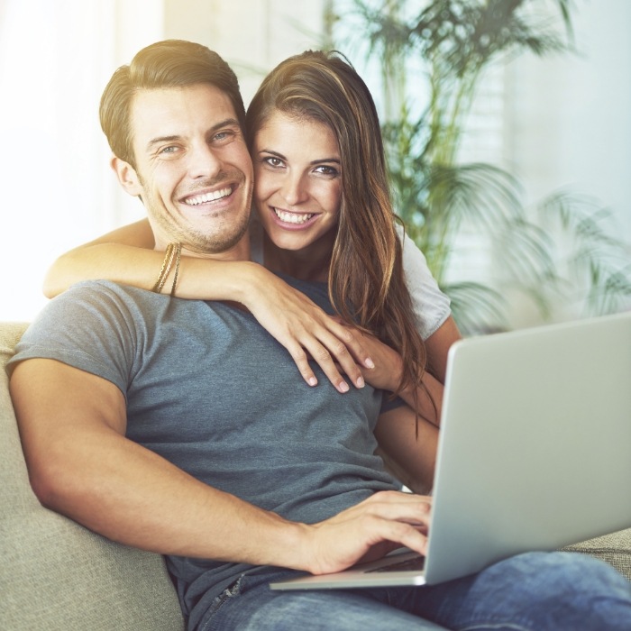 Man and woman with laptop reading dentist reviews in Arlington