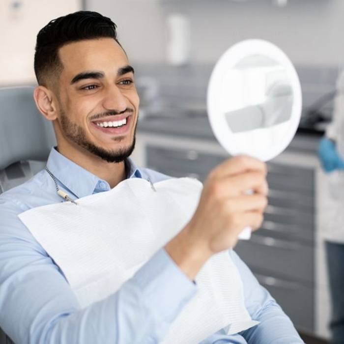 a patient smiling after receiving his veneers